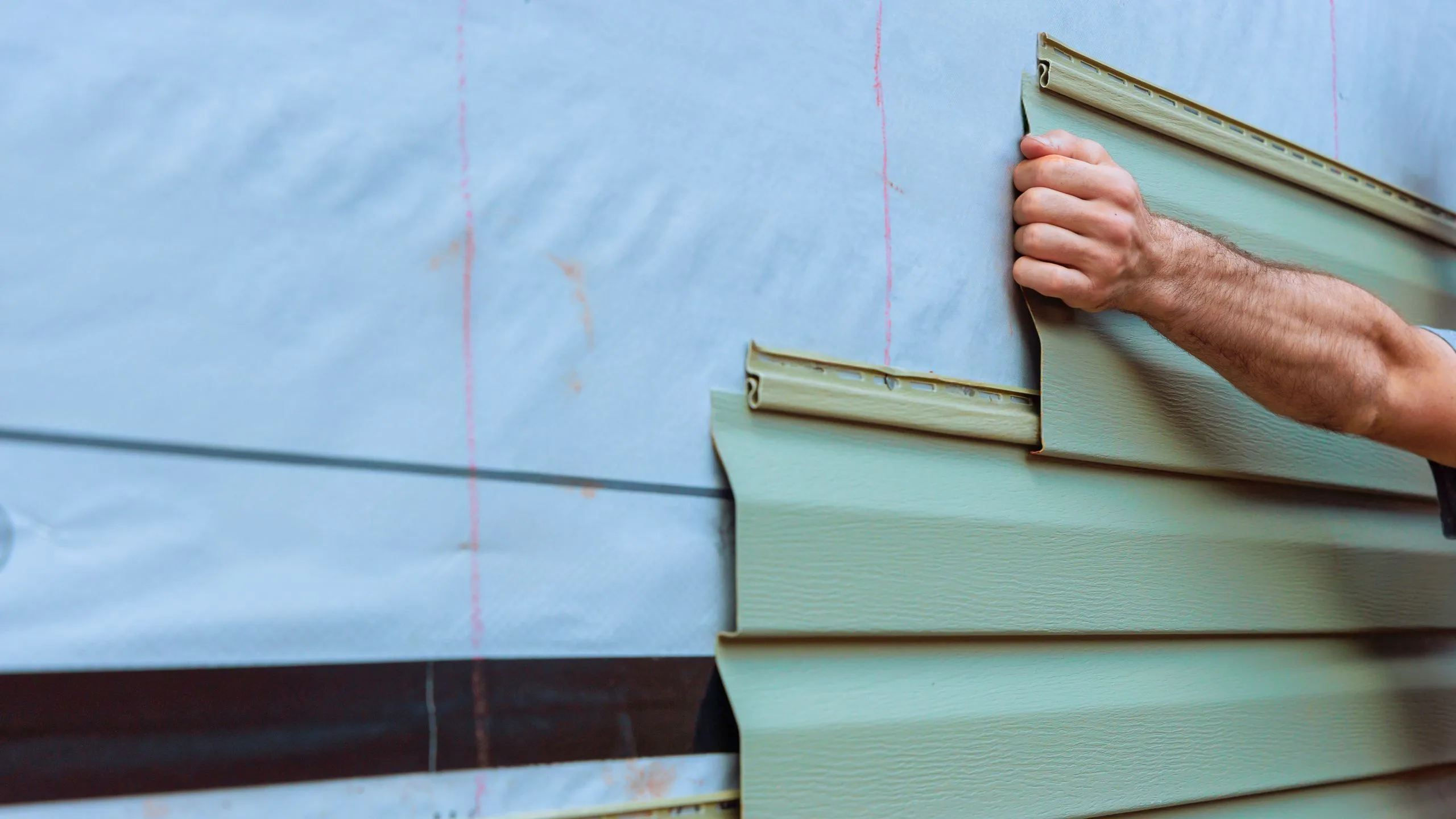 Contractor assessing siding condition on a Hamilton home to determine whether repair or full replacement is needed